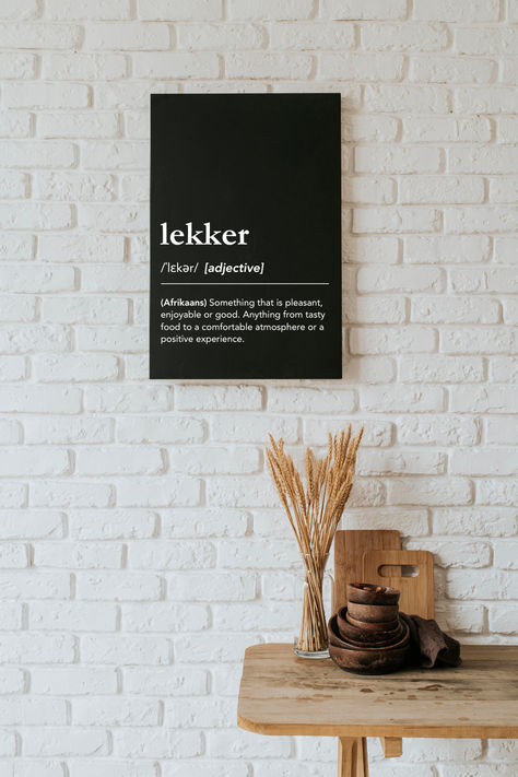 What does lekker mean? Lekker definition, meaning of lekker, pronunciation of lekker. Something that is pleasant, enjoyable or good. Anything from tasty food to a comfortable atmosphere or a positive experience. Minimalist dictionary style wall art for kitchen or dining room, south african culture, south african slang, proudly south african, lekker man, afrikaans sayings, south african sayings, african words, south african expat, born in south africa, #lagunaklein #lekker #southafrica South African Decor Ideas, Afrikaans Aesthetic, South African Aesthetic, Dictionary Aesthetic, African Sayings, South Africa Quotes, South African Decor, South African Culture, Aesthetic Kitchen Decor