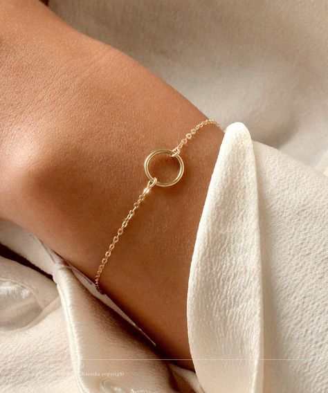 14K Solid Gold Karma Bracelet * Small Ring Bracelet * Delicate Open Circle Bracelet * Eternity Bracelet * Layering Bracelet * Simple PRODUCT DESCRIPTION Our modern everyday Vogue bracelet features a karma circle on a stunning dainty chain. Simple and minimal and the perfect go-to piece. Soft colours and a high quality piece. DETAILS & MATERIALS * Sterling Silver, 14K Gold Filled, 14K Rose Gold Filled & 14K Solid Gold materials. * 10mm circle. * Circles available in smooth or hand hammered finish Minimalist Recycled Gold Round Bracelets, Minimal Gold Bracelet, Delicate Round Bracelets With Simple Design, Minimalist Round Hypoallergenic Chain Bracelet, Minimalist 14k Gold Round Chain Bracelet, Simple Bracelets Gold, Minimalist Round Bracelet With Adjustable Length, Minimalist Accessories Jewellery, Minimal Gold Jewelry