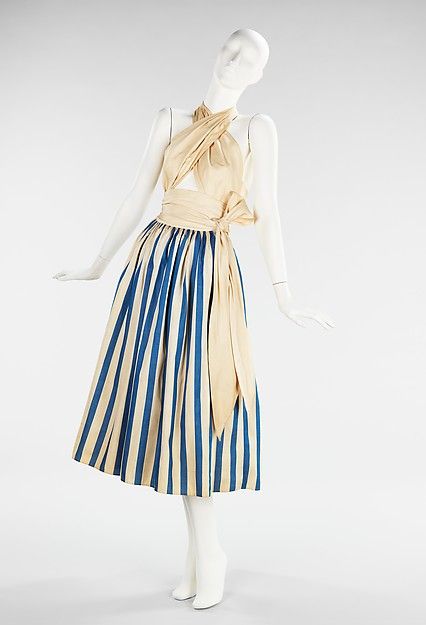 Sundress by Claire McCardell (1945). McCardell was a pioneer of American fashion. She was known for her use of natural fabrics, casual looks, and flattering silhouettes. I love the halter, crisscross style of this top. Very fashionable still today. Fashion History Timeline, Claire Mccardell, Cotton Wrap Dress, Fashion 1940s, 20th Century Fashion, Cotton Sundress, Costume Collection, Vestidos Vintage, Mass Production