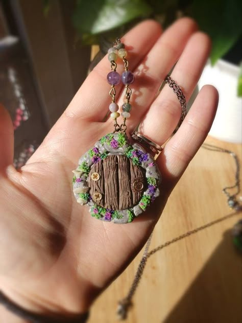 A magical mini fairy door you can wear around your neck! All of the details were carefully sculpted without using and paints or molds.  The pendant features mini mushrooms, moss and other details using the smallest screws I had! The beaded accessories are also hand made with real Amethyst and other semi precious stones. Clay Necklace Pendant Diy, Fairy Inspired Jewelry, Polymer Clay Cottagecore, Fairy Trinkets, Cottagecore Polymer Clay, Polymer Clay Nature, Fairy Moss, Fairy Portal, Polymer Clay Pendants