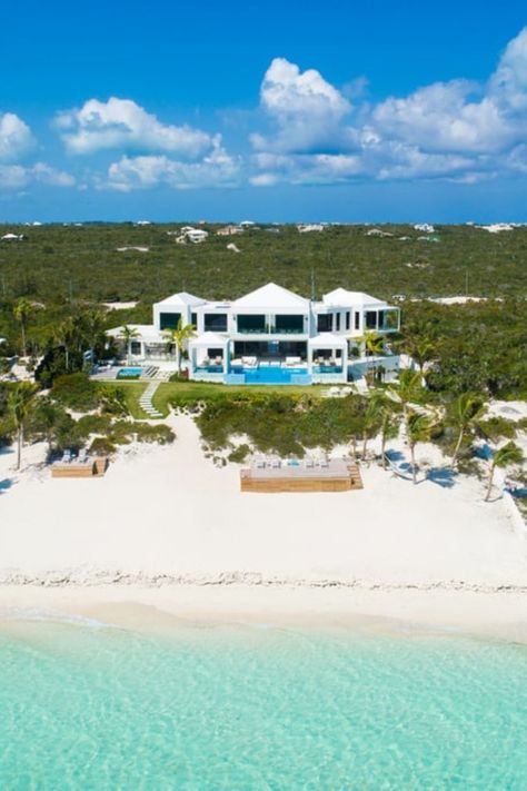 This is an aerial view of the beach house exterior with its bright white exterior walls that stand out against the green landscape. Out in front are the crystal clear waters of the ocean that looks as pristine as the villa's home exterior and landscaping. Tap on through for a peak at the luxury interior. Courtesy of Toptenrealestatedeals.com Big House Near Beach, Beach Front Mansion, House With Private Beach, Mansion By The Beach, Beach Front Homes Ocean Views, Luxury Beach House Exterior, Dream Beach Houses The Ocean, Villa House Exterior, House Exterior Beach