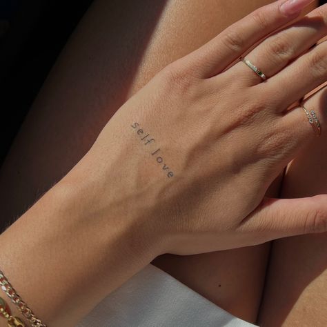 Small Hand And Finger Tattoos For Women, Hand Tattoos For Women Quotes, Small Self Love Quote Tattoos, Single Word Hand Tattoos, Tattoo Writing On Hand, Dainty Hand Tattoos For Women Words, Small Word Hand Tattoos For Women, Self Love Hand Tattoo, Self Love Words Tattoo