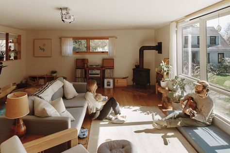 Photo 12 of 16 in My House: A Creative Renovation Inspires Two Musicians to Put Down Roots on the Rhode Island Coast - Dwell Musician Living Room, Chair Corner, Light Hardwood, Light Hardwood Floors, County House, Corner Fireplace, Media Cabinet, Rug Floor, My House