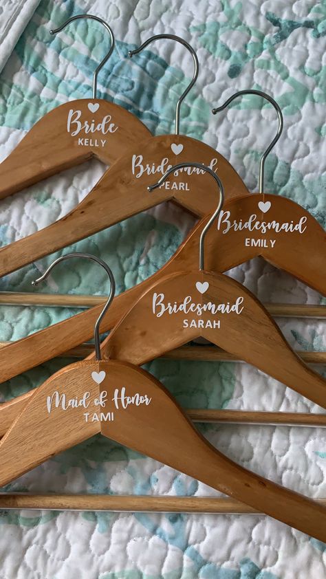 Bridal party hangers, hangers from Aldi used white permanent vinyl for the names and titles Wedding Decor Made With Cricut, Bridal Party Box Ideas, Hangers For Bridal Party, Cricut Projects For Bridal Showers, Bridal Cricut Ideas, Wedding Stuff Made With Cricut, Cricut Ideas For Wedding Decor, Bridal Party Get Together Ideas, Wood Hangers Wedding