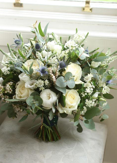 Loose hand-tied bouquet in white, blue and green with roses, peonies, eustoma, astrantia, veronica, thistles, waxflower and a sprig of scottish heather. Mixed seasonal foliage. Tied with tartan ribbon. Scottish Flower Bouquet, Eucalyptus Bridal Bouquet White Flowers, Blue Thistle Bridal Bouquet, Wedding Bouquet With Blue Thistle, Bridal Bouquet With Thistle, White Veronica Bouquet, Thistles Bouquet, Veronica Bouquet, White Bouquet With Blue Thistle