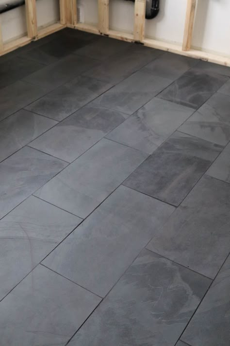 Dark Tile Bedroom Floor, Black Slate Bathroom Floor Master Bath, Dark Basement Bathroom Ideas, Dark Grey Slate Tile Floor, Ways To Lay 12x24 Tile, Slate Tile Master Bath, Dark Gray Tile Bathroom Floor, Black Tile Brown Grout, Gray Tile With Dark Grout