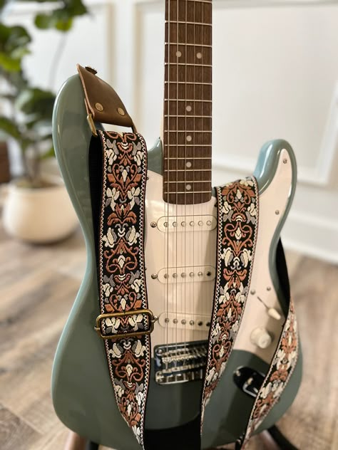 Handmade in Knoxville, TN!  This strong and durable guitar strap features genuine leather ends and a black strap with a brown, gray and white embroidered floral pattern.  Made with antique brass hardware.   Strap is adjustable from 34.5-60" (87.6-152.4 CM) and is 2" (5 CM) wide ~Message me if you would like a custom length!~ I can also use any of my 2" webbings to make a guitar strap so if you see a pattern on my site you would like please let me know!   www.etsy.com/shop/TFCOStraps Bass Guitar Design, Guitar Strap Aesthetic, Floral Electric Guitar, Embroidery Guitar Strap, Floral Guitar, Painted Guitar Strap, Cool Guitar Straps, Cute Guitar Straps, Pretty Guitar Straps