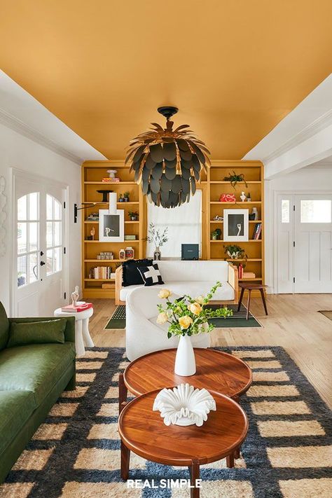 5 Unexpected Decor Ideas to Add Interest to Every Room | A bold home decor idea, follow designer Natalie Papier's lead and paint a wide stripe down the center of the ceiling, then continue the hue onto the far wall. The color shown here is Bugle Call by Valspar, a rich shade of orange. To achieve the crisp, clean lines, painter's tape is your best friend. #decorideas #homedecor #decorinspiration #realsimple #smallspaceideas #apartmentideas New Build House Decor, Ceiling Ideas Living Room, Narrow Room, Yellow Ceiling, Orange Rooms, Narrow Rooms, Living Room Orange, Baby One More Time, Colored Ceiling