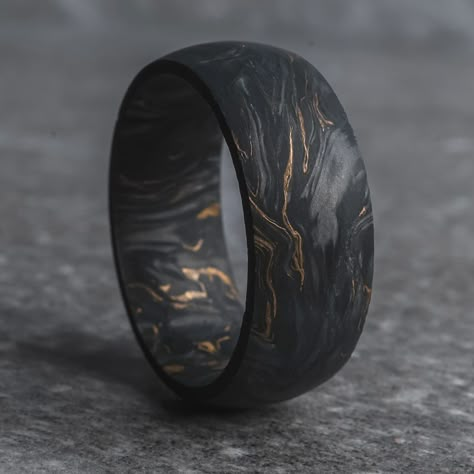 The Grand Prix is a forged black carbon fiber wedding ring crafted with formula-one grade 24,000 carbon fiber tow - pressurized with gold leaf flake, giving it a signature "marbled" aesthetic. Each carbon fiber ring is going to have a unique pattern, so every ring will be truly one-of-a-kind. If you're looking for a wedding ring that's exclusive to you, The Grand Prix is the carbon fiber ring to go with. This ring is made exclusively with carbon fiber, which means it's safe for wear by electrici Mens Tungsten Wedding Rings, Rustic Mens Wedding Bands, Carbon Fiber Ring, Unique Mens Jewelry, Titanium Mens Wedding Band, Mens Wedding Rings Gold Unique, Unique Men’s Wedding Rings, Couple Wedding Rings Unique, Black Ring