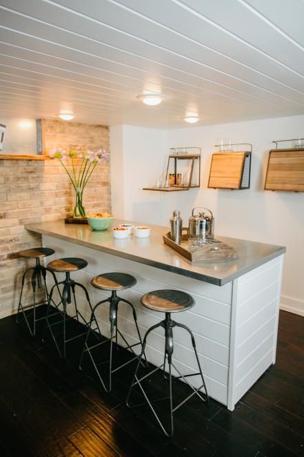 The+new+bar+has+wrapped+metal+countertop+and+industrial+style+barstools. Bonus Room Design, Renovation Plan, Modern Basement, Basement Bar Designs, Home Bar Design, Small Basements, Coastal Living Rooms, Beach House Style, Basement Flooring