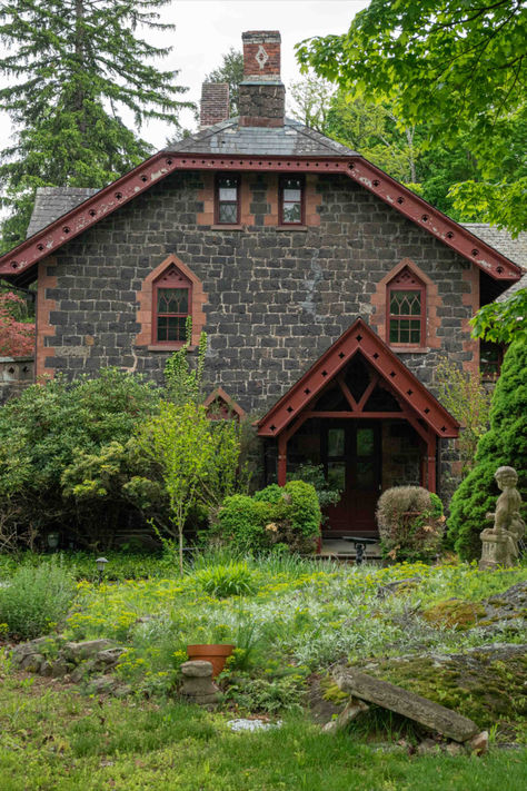 Steeped in history and loaded with charming, authentic architectural details, this tucked-away stone villa in the woods is just a few minutes north of New York City. The fairytale three-story home, completed in 1865, is a Gothic Revival showpiece of mostly granite, and the 12-room main house includes diamond-paned windows, a black marble fireplace, pocket doors in the library, and hardwood floors. Six private park-like acres surround the seven-bedroom home.

65 Rockland Road • Sparkill, New York Stone Victorian House, Stone Houses Rustic, Villa In The Woods, Stone House In Forest, Storybook Stone Cottage, Gothic Stone House, Black Marble Fireplace, Stone House Revival, Gothic Revival Cottage