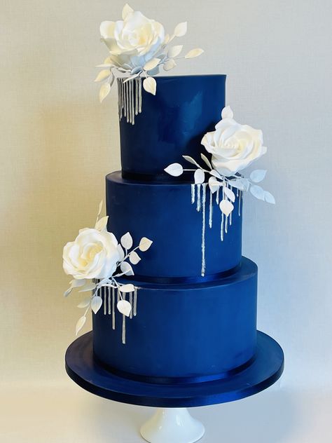 Selena, dramatic navy blue wedding cake with silver drip and statement white sugar rose sprays Royal Blue Wedding Cakes Elegant, Navy Blue And Purple Wedding Cake, Navy Blue White And Gold Wedding Cake, Navy Blue Cake Ideas, Royal Blue And Silver Cake, Blue And Black Cake, Navy Wedding Cakes, Dark Blue Cake, Wedding Cake Designs Blue