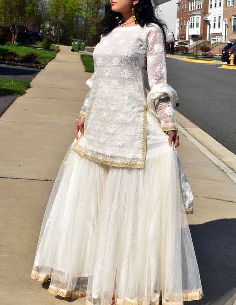 Our white and gold garara set is the go to 'simple but elegant outfit.' Perfect for any kind of event. The top features net embroidery with gold lace, the flare garara is made from a shimmery cloth adding some sparkle to the outfit. Completing the look we went ahead and matched a polka dot print dupatta featuring some gold  lace. Fully stitched. Please allow design(print) and slight color variations. We are now accepting all US based Eid orders till April 25th for guaranteed delivery by Eid-ul-f Simple White Gharara Pakistani, White Garara Dress Pakistani Bridal, New Garara Designs, Garara Designs Pakistani Dresses, Garara Design, White Gharara, Garara Designs, Garara Dress, Garments Design