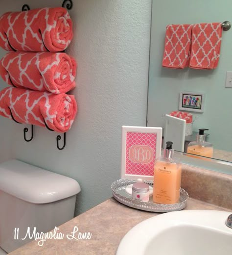 aqua coral bathroom - and I'm thinking of adding some framed vintage pictures or old vogue magazines to the wall. Perfect. Wine Rack For Towels, Coral Bathroom Decor, Coral Bathroom, Bathroom Organization Hacks, Apartment Decoration, Small Bathroom Storage, Apartment Life, Girls Bathroom, My New Room