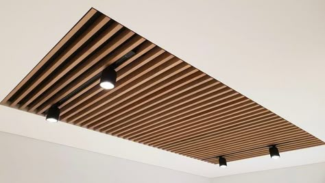 Wood And Gypsum Ceiling, False Ceiling Wood Design, Wood Slat Ceiling Lighting, Natural Ceiling Design, False Ceiling With Track Lights, Wood Ceiling Office, Wood Slats Ceiling, Toilet Ceiling Design, Wood Ceiling Ideas Modern