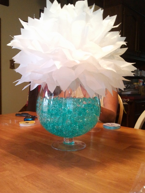 fish bowl vase:  bowl filled with clear and turquoise water beads from walmart  tissue paper flower: 8 sheets of tissue paper folded into an accordion with wire tied halfway. once folded together, pull individual pieces away from center to make fuller.( LOVE, its cheap and looks chic <3) Fishbowl Centerpiece, Fish Bowl Vases, Housewarming Ideas, Quince Stuff, Quince Decor, Race Night, Filled Vases, 21st Bday Ideas, Staff Party