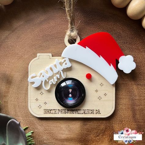 Transform your home decor with innovative laser cut ideas perfect for the holidays! Explore cute decorations, custom trophies, and engraved items that enhance any festive celebration. Elf Camera, Santa Camera Ornament, Laser Cut Ideas, Santa Camera, Elf Surveillance, Santa Cam Ornament, Elf Cam, Laser Cut Decor, Santa Cam