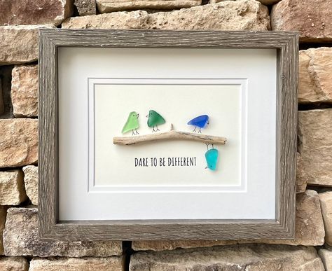 Handmade sea glass artwork featuring seaglass birds in a variety of colors sitting on a branch with the message "Dare to Be Different". Perfect inspirational gift. Don't be afraid to be yourself! Each piece is unique and I hope you find as much joy in looking upon your new piece as I took in creating it!  This artwork measures 8 x 8 unframed and includes a high quality gray wood display case frame.  While you can find all of my ready-to-ship pieces of art currently on Etsy, I would be more than Seaglass Birds On A Branch, Fishing Sea Glass Art, Bird Sea Glass Art, Sea Glass Birds On A Branch, Seaglass Pictures Diy, Beach Glass Art Diy, Seaglass Art Ideas, Seaglass Birds, Beach Glass Projects