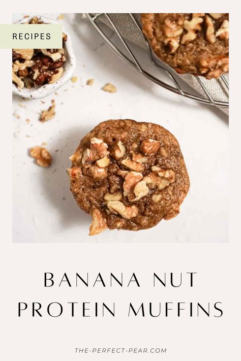 A banana nut protein muffin next to another muffin and small bowl of walnuts. Healthy Banana Nut Muffins, Healthy Breakfast Muffins Protein, High Protein Banana Muffins, Protein Banana Muffins, Healthy Banana Nut Muffins Clean Eating, Banana Bread Muffins Protein, Gluten Free Banana Protein Muffins, Banana Muffins Protein Powder, Banana Nut Bread Muffins