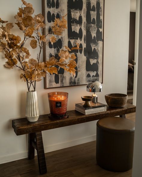 A new hallway vignette featuring my favorite fall candle and some of my new favorite fall stems! 🍂🍁 If y’all saw my new bedding reel, I shared this new bench from @potterybarn and I wanted to try it in the hallway into my living space, it looks good anywhere! Also, if you haven’t tried Forbidden Fig by @voluspacandles, you need to get on it! Not only is the glass vessel gorgeous, but this scent is the perfect warm scent for fall. 🫡 Hallway Vignette, Interior Design Table, Fall Stems, Table Candle, Fall Stem, New Bedding, Fall Candle, Candle Table, Candle Sticks