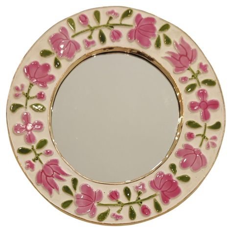 This beautiful colored mirror, whose discreet irregularity is its charm, is one of the variations described as "romantic", produced in the mid-1960s. Decorated with delicate pink and green floral motifs on a white background, the enamel reveals a light preciosity and unparalleled gaiety. How is Mithé Espelt? Marie-Thérèse Espelt, better known as Mithé Espelt, was born in 1923 in Lunel in the Camargue region of southern France. She grew up surrounded by the exceptional social circle of her grandf Cute Mirror Wall Decor, Light Pink Aesthetic Room Decor, Flowers Painted On Mirror, Pink And Green Room Decor, Mirror Painting Ideas Art, Round Mirror Frame, Green Room Decor, Line Vautrin, Painted Mirror