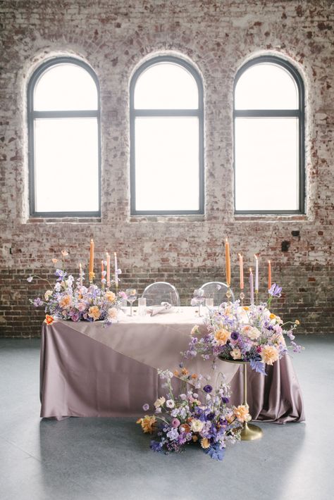 The 60s Just Got a Modern Makeover That’s Perfect for Your Wedding - Green Wedding Shoes Wedding Sweetheart Table Flowers, Table Flowers Wedding, Sweetheart Table Flowers, Pastel Candle, Sweetheart Table Wedding, Wedding Decor Ideas, Lilac Wedding, Bridal Table, Wedding Dress Boutiques