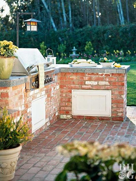 Slate countertops in this kitchen double as a food prep area and a buffet space where visitors can mingle and munch. You can even place seating on the other side of the counter for more space to mix and mingle. The brick and stainless-steel grill are good materials for outdoor use and offer a sleek look. Brick Grill, Small Outdoor Kitchens, Outdoor Grill Area, Brick Bbq, Outdoor Bbq Area, Backyard Barbeque, Outdoor Kitchen Countertops, Outdoor Bbq Kitchen, Outdoor Kitchen Ideas