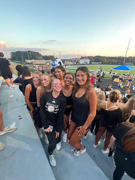 A group of teenagers take a picture together before a blackout highschool football game Black Out For Football Games, Football Blackout Theme, Black Out Themed Football Game, White Out Themed Football Game, Blackout Football Game, Themes For Football Games High School, Blackout Football Game Theme Outfit, Black Out Football Game Outfits, Football Game Outfit Highschool