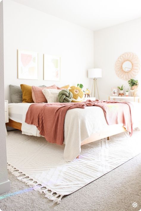 My favorite bedroom styling to date 🥰 loving the bright pinks, yellows, and greens. So summery! White Bedding Ideas Pop Of Color Pink, White Bedding With Pop Of Color, Pink And Wicker Bedroom, Pink Green Cream Bedroom, Sage Green Pink And Mustard Bedroom, White Orange Pink Bedroom, Pink Yellow White Green Bedroom, Neutral Bedroom With Yellow Accent, Pink Bed Styling