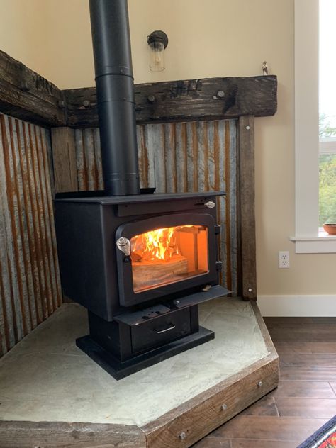 Wood Stove Tin Surround, Corrugated Metal Wood Stove Surround, Manufactured Home Wood Stove, Rustic Hearth Ideas, Shed Fireplace, Rustic Wood Burning Stove, Wood Stove Metal Surround, Woodstove Surrounds Metal, Corner Wood Stove Mantel Ideas