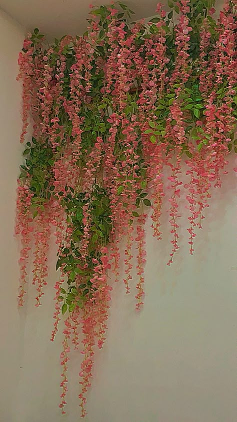 it is pink flowers hanging by a white wall Pink And Green Plant Aesthetic, Cottage Pink Aesthetic, Pink Green And White Aesthetic, Green And Pink Aesthetic Room, Indie Pink Aesthetic, Brown Green Pink Aesthetic, Light Green Pink Aesthetic, Pink Green And Brown Aesthetic, Pink Orange And Green Bedroom