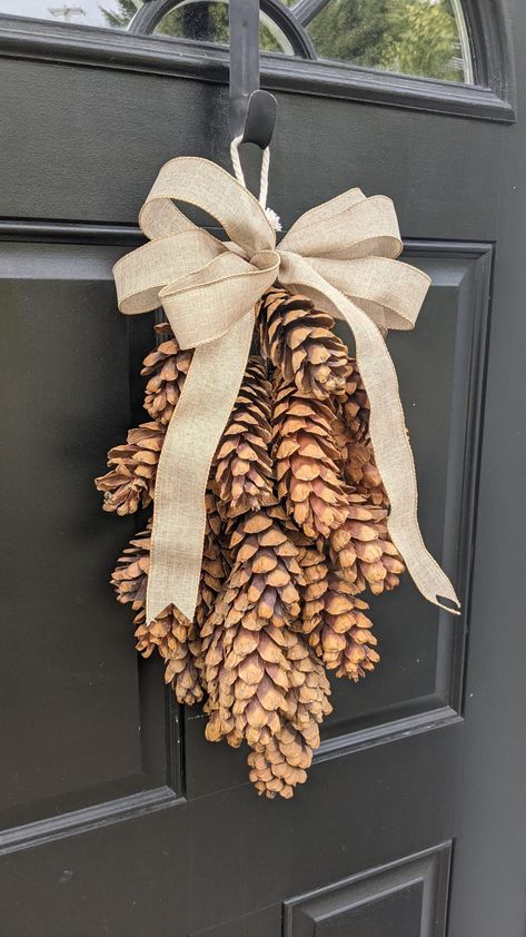 I created this all natural, very rustic- looking pine cone swag using real pine cones hand foraged by me. They've been soaked in a water and vinegar solution and baked in the oven for hours until fully opened. Once opened and cooled, each cone was painstakingly wired and attatched it to a slim, neutral, braided rope which also serves as the hanger at the top.  The mechanics are very visible on the back as this is a truly an all nautral, handcrafted, rustic piece. So unique! They're gorgeous. PLE Long Pinecone Crafts, Pine Cone Crafts Christmas, Wreath Swag, What To Do With Pinecones, Diy Pinecone Decor, Pine Cone Santa, Pinecone Christmas Decor, Pine Cone Wreaths Diy, Pine Cones Decorations