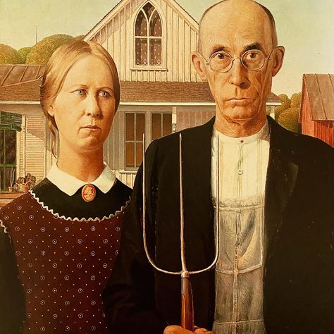 Grant Wood painted this portrait the way a theater director puts on a show. First he discovered the setting. Wood saw the house, now famous for inspiring American Gothic, in a small Iowa town and knew it had to be in a painting. Then he cast his sister and dentist to play the two roles. Many presume them farmer and daughter. But that’s never been nailed down. In fact, the painter left it ambiguous on purpose. Learn more with a click to LadyKflo’s Art Blog. #americangothic #grantwood #region American Gothic House, American Gothic Painting, American Gothic Parody, Grant Wood American Gothic, Front Of A House, David Choe, Grant Wood, Istoria Artei, Jan Van Eyck