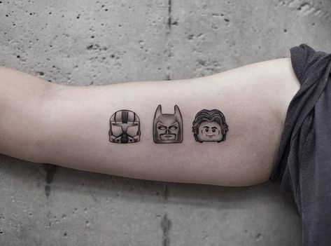 LEGO’s Minifigure head tattoos by Aki Wong tattooed on the right bicep Lego Heart Tattoo, Matching Lego Tattoo, Lego Movie Tattoo, Lego Head Tattoo, Lego Figure Tattoo, Positive Symbols, Types Of Feathers, Lego Head, Owl Feather