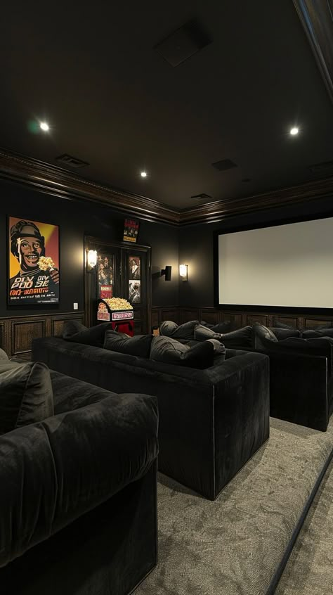 Dark-toned luxury home theater with plush sofas, large screen, ambient lighting, and movie posters for a cinematic experience. Industrial Theater Room, Dark Movie Room, Home Movie Room Ideas, Cinema Room Ideas, Cinema Living Room, Movie Theatre Room, Cinema Room Decor, Home Cinema Room Ideas, Luxury Home Cinema Room