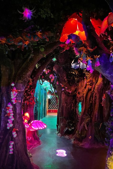 a dark pathway leads the viewer through a forest lit with glowing flowers and leaves. at the end the pathway is green tunnel. Experiential Art, Neon Jungle, Outdoor Gazebo, 30 July, Magic Forest, Forest Theme, Alice In Wonderland Party, Halloween Trees, July 2022