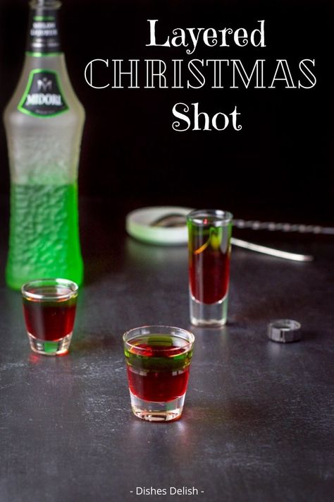 A beautiful and delicious shot. The Christmas shot is perfect to serve at your holiday party! #christmashot #christmasdrink #christmascocktail #drink #dishesdelishcocktail @dishesdelish | dishesdelish.com 12 Shots Of Christmas, Xmas Shots Alcohol, Christmas Party Shots Holiday Drinks, Winter Shot Recipes, Christmas Shots Alcohol Recipes, Easy Christmas Shots Recipes, Fun Christmas Shots, Holiday Shots Christmas, Christmas Shooters Holiday Drinks