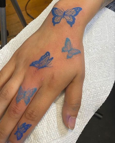 All Blue Tattoos For Women, Blue Butterfly Tattoo On Hand, Blue Butterfly Hand Tattoo, Pretty Blue Tattoos, Blue Tattoo Butterfly, Red Butterfly Hand Tattoo, Cute Simple Hand Tattoos, Blue Outline Tattoo, Butterfly Tattoo On Hand For Women