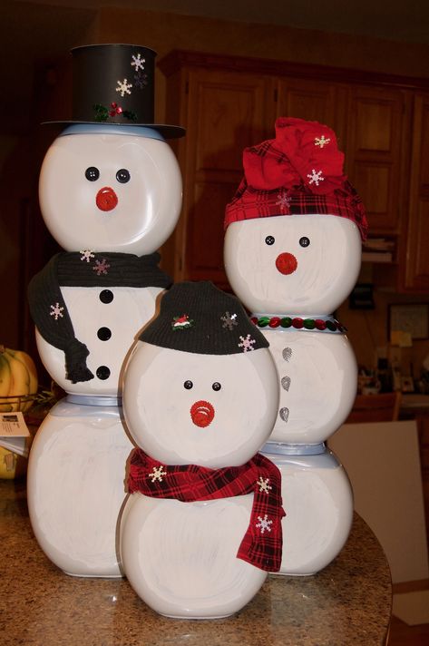 This snowman family was made from white Tide Pod containers and decorated with stuff from around the house! An old pair of leggings was cut up to make the red hat and scarf. An old sweater made the dark green hat and scarf. Buttons for eyes, coiled pipecleaners for noses, poster board for the top hat, and sequins to add some bling. These will decorate my husband's office for a holiday contest; his theme is 'Reduce - Reuse - Regift'. :) Recycle Tide Pod Containers, Upcycle Laundry Pod Containers, Snowman Out Of Tide Pod Container, Crafts With Pod Containers, Tide Pods Container Crafts Diy, Tide Pod Christmas Craft, Tide Pod Containers Crafts, Gain Container Crafts, Snowman Tide Pod Container