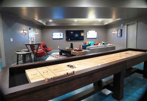 Gray basement living room with contemporary furniture and shuffleboard table Room Conversion Ideas, Bedroom Design For Men, Garage Room Conversion, Trendy Bedroom Design, Gray Basement, Cool Basement Ideas, Finished Basement Designs, Basement Paint Colors, Gaming Lounge