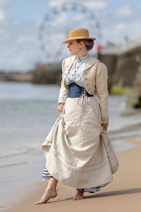 Our Sylvia Edwardian Walking Skirt is an elegant long, linen skirt perfect for Edwardian costume or a modern vintage style skirt. An elegant and feminine skirt which sweeps to the ground, it is typical of the Edwardian walking skirt styles worn from 1890 to 1908 in the era known as the Belle Epoque or the Gilded Age. Perfect for historical re-enactment, theatre, steampunk or just every day. Made from a lovely quality 100% medium weight linen, the skirt features gored panels that skim the hips then flares out with pleating in the back for extra fullness with a sweeper train. The back is approx 4"/10cm longer than the front. The waistband fastens with a button and hooks and eyes, and there's an extra button for a little flexibility. The skirt is trimmed with a double narrow velvet ribbon ban Western Outfits Women 1800s, Modern Edwardian Fashion, Edwardian Fashion Women, Edwardian Walking Skirt, Titanic Fashion, Witch Oc, Walking Skirt, Edwardian Costumes, Edwardian Corsets