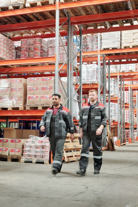 Two young intercultural male workers in uniform moving along large factory by Pressmaster. Two young intercultural male workers in uniform moving along large factory or warehouse with huge shelves with packed... #Sponsored #workers, #uniform, #moving, #young Factory Photoshoot, Work From Home Canada, 2000s Fashion Men, Factory Photography, Visa Sponsorship, Apply Job, Teamwork Skills, Factory Worker, Modern Factory