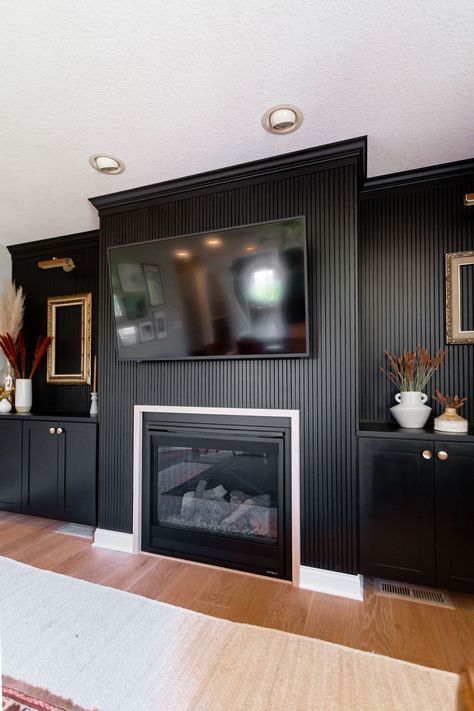 Wood Slat Fireplace Wall With Mantle, Black Fluted Fireplace, Mantle Black Fireplace, Wood Panel Fireplace Wall, Wood Panel Fireplace, Black Living Room Walls, Black Modern Fireplace, Dark Fireplace Wall, Vertical Wood Slat Wall