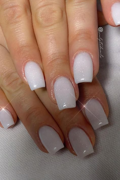 Elegant and understated, these white glitter nails are a vision of subtle sparkle. The almond shape offers sophistication, while the white base is elevated with a dusting of fine glitter that catches the light, reminiscent of a gentle snowfall. Perfect for any occasion that calls for a touch of refined glamor. ✨  // Photo Credit: Instagram @sculptednails Shimmering White Nails, White Sparkle Nails Square, Irredecent Nails White, White Shine Nails, White Frosted Nails, White Squoval Nails, Winter Engagement Nails, White Shiny Nails, Milky Glitter Nails