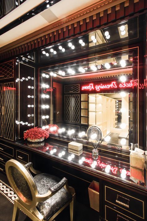 This dressing room is part of a Las Vegas themed suite in central London. The room is fully fitted in bespoke joinery finished in ebony walnut, gold leaf pattern work and gold plated metalwork with sycamore joinery to the walk-in wardrobe. The custom Hollywood mirror includes hand blown glass bulbs. A bespoke carpet design and personalized neon lighting feature complete the aesthetic. Designed by Architect Mike MacAusland. Drag Dressing Room, Neon Dressing Room, Hollywood Glam Aesthetic Room, Fancy Dressing Room, Old Hollywood Dressing Room, Old Hollywood Room, Hollywood Aesthetic Room, Old Hollywood Aesthetic Room, Dressing Room Aesthetic