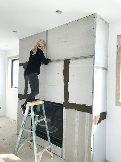 A DIY Concrete Fireplace That Cost Less Than $250 | domino Concrete Skim Coat Fireplace, Diy Cement Fireplace Surround, Cement Smear Fireplace, Concrete Paint Fireplace, Cement Fireplace Makeover, Fireplace Wall Finishes, Board Formed Concrete Fireplace, Symmetrical Living Room With Fireplace, Plastered Fireplace Ideas