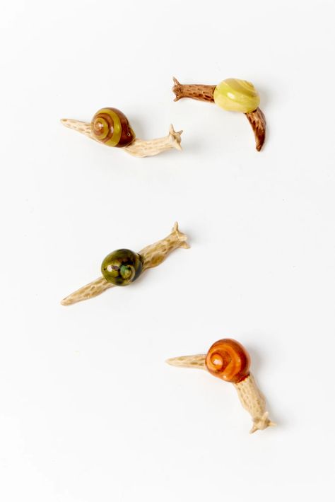 ... all together now ﻿﻿Imagine your guests finding these hand-painted ceramic snails under flower petals, perched on breadsticks, holding down a napkin, or gathering on moss. Each snail is handmade and glazed in Paris.  Part of “The Myrrh, The Merrier” and “A Royal Affair” collections.  2.5"l x .75"h Snail Pottery, Ceramic Snails, Advanced Crafts, Ceramic Snail, Pottery Throwing, All Together Now, A Royal Affair, Pottery Gifts, Instagram Gift