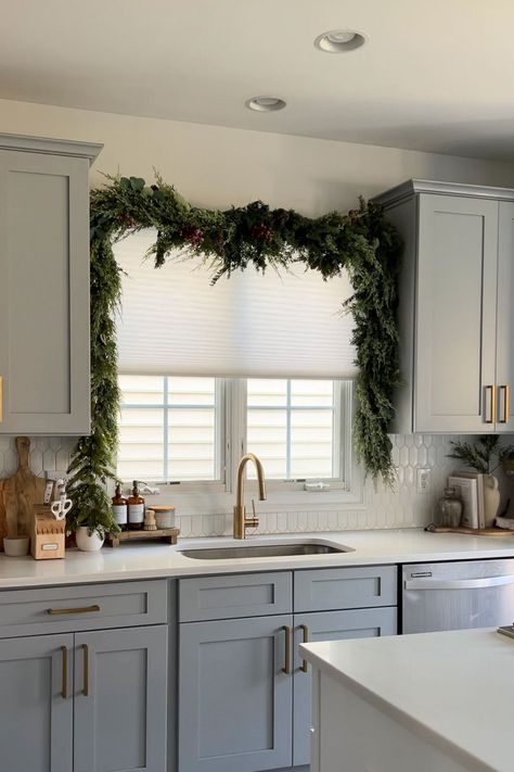 Here's Proof the Viral Christmas Garland Hack Taking Over TikTok Actually Works Kitchen Island Garland, Garland Over Kitchen Sink Window, Christmas Garland Above Kitchen Sink, Garland Over Kitchen Sink, Christmas Wreath For Kitchen Cabinets, Christmas Garland On Windows Inside, Christmas Garland On Cabinets, Above Cabinet Garland, How To Hang Garland Over Window