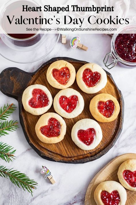 These Valentine's Day Cookies are made with a simple cookie dough and a cute heart shaped imprint filled with raspberry jam. Heart Shaped Jam Cookies Recipe, Raspberry Heart Cookies, Thumbprint Cookies Heart, Heart Thumbprint Cookies, Heart Jam Cookies, Shaped Cookies Recipe, Heart Cookies Recipe, Raspberry Thumbprint Cookies, Simple Cookie