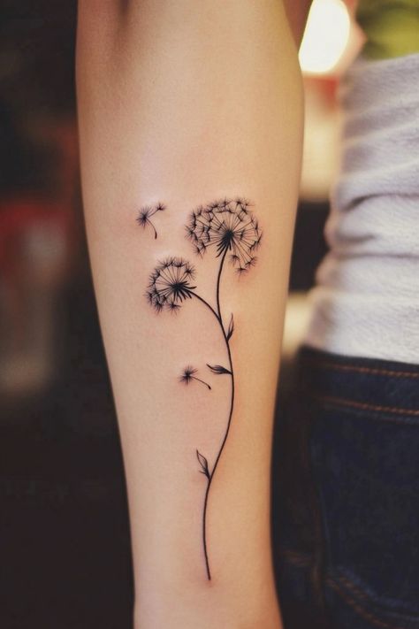 Dandelion tattoo on an arm with seeds blowing away. Dandelion Rib Tattoo, New Beginning Tattoos, Wish Flower Tattoo, Dandelions Tattoos, Wind Tattoos, Blowing Dandelion Tattoo, Dandelion Tattoo Ideas, Dandelion Tattoo Meaning, Whimsical Tattoo